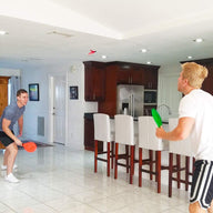 Friends playing Jazzminton indoors by the kitchen