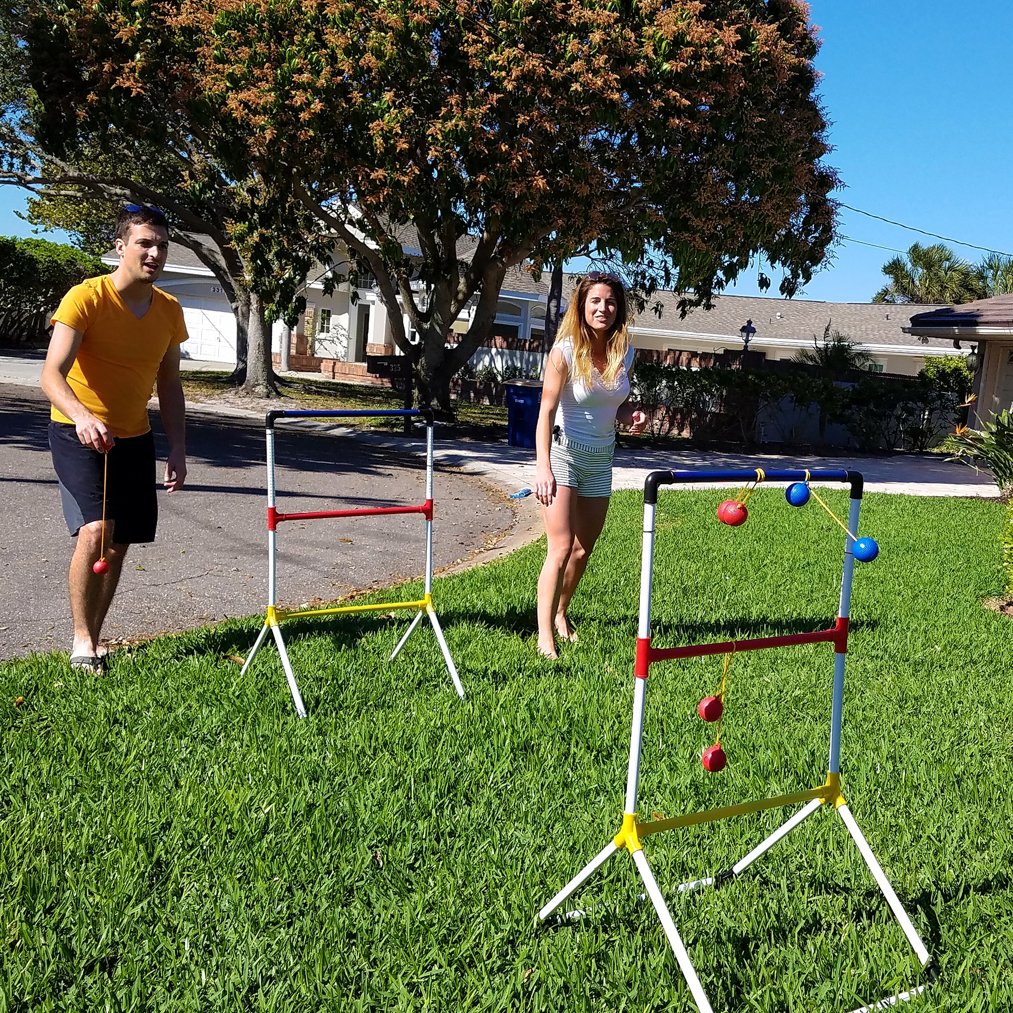 siblings playing ladder golf set in front yard