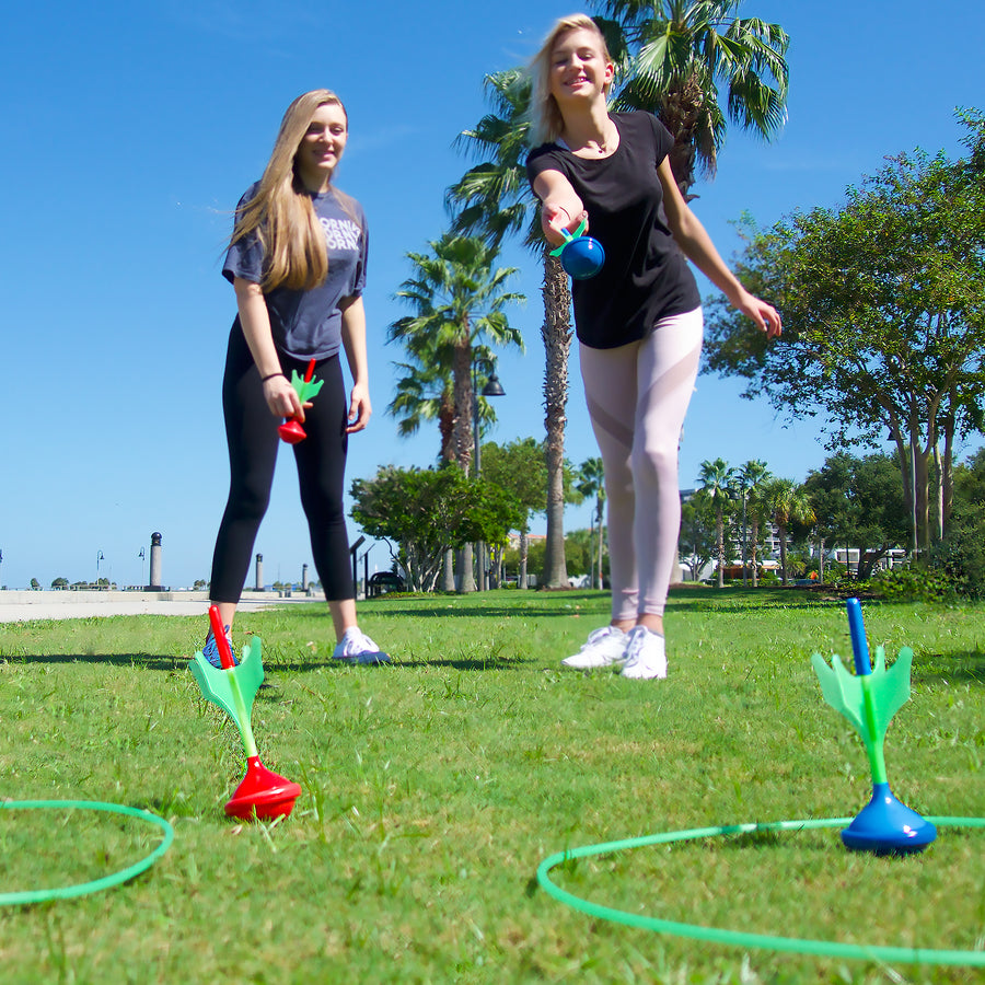 Two friends playing Lawn Darts at the park