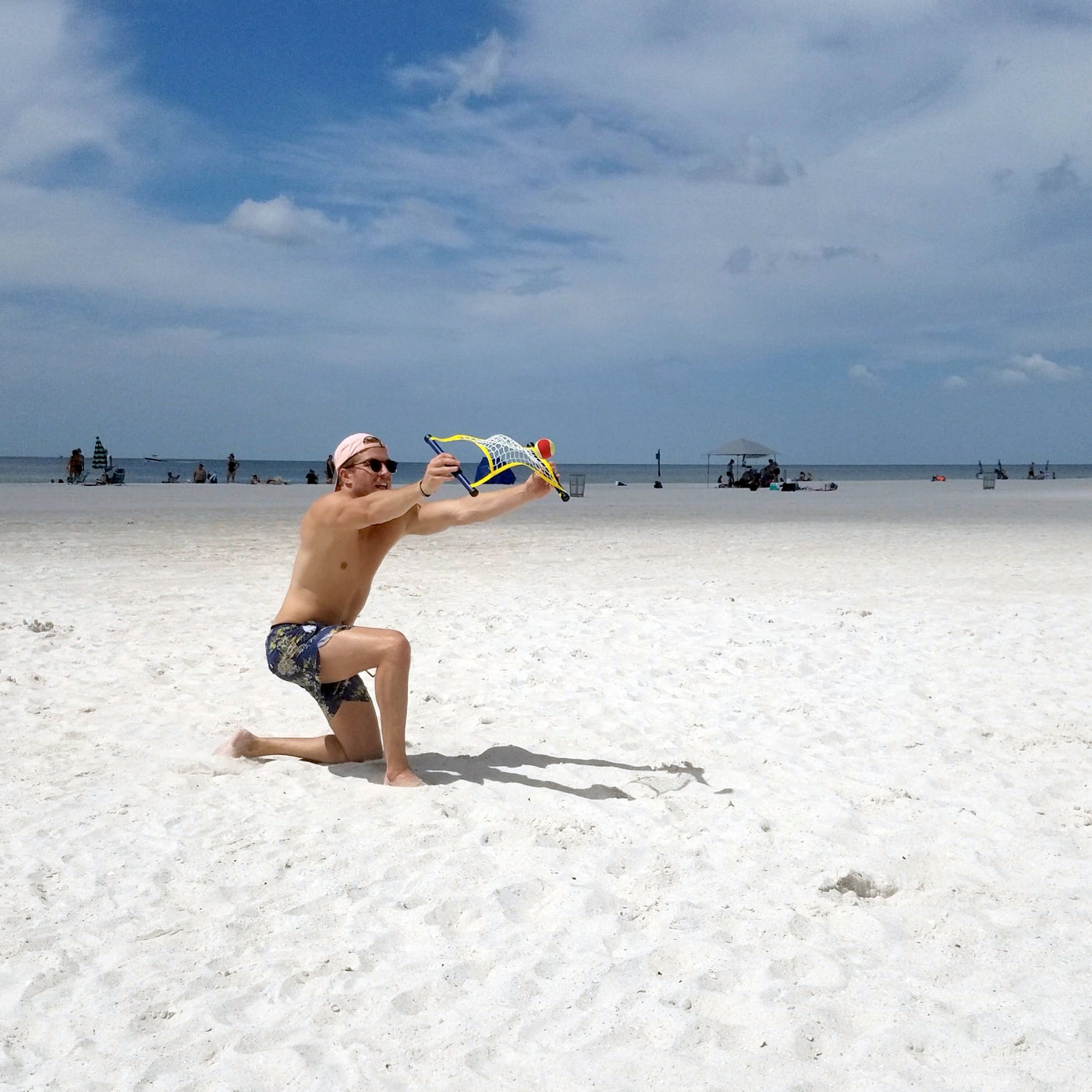 Guy hitting ball off net playing Switch Ball on the beach